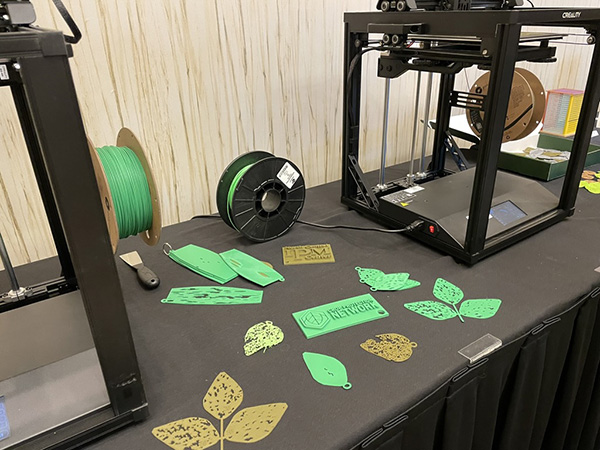 3d printers sitting on table with examples of 3d-printed leaves