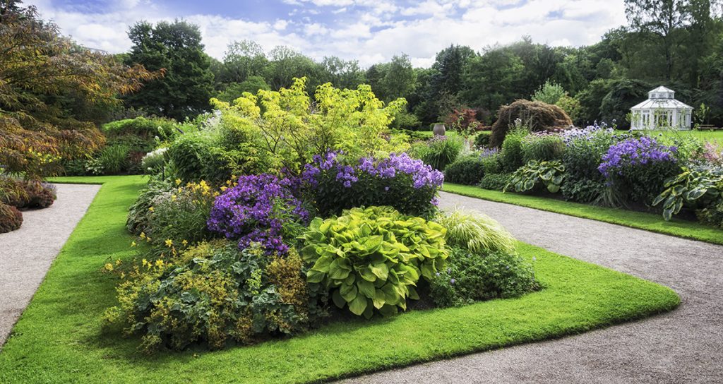 Botanical garden with a beautiful landscape of blooming plants surrounded by well-maintained turf.