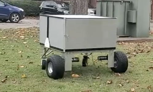 laser robot; a giant metal box positioned on four wheels with large tires in back and small tires in front