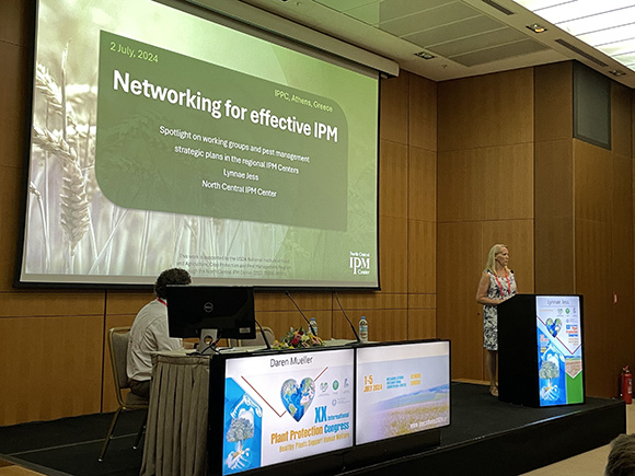 Lynnae Jess standing behind a podium as she presents at the International Plant Protection Congress